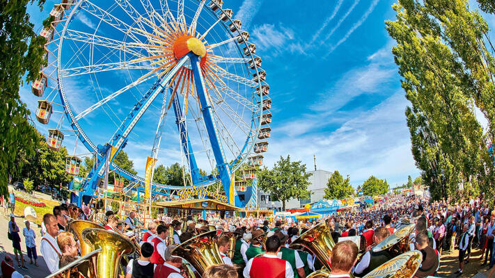 Ansicht des Riesenrads auf dem Gäubodenvolksfest mit Musikern im Vordergrund